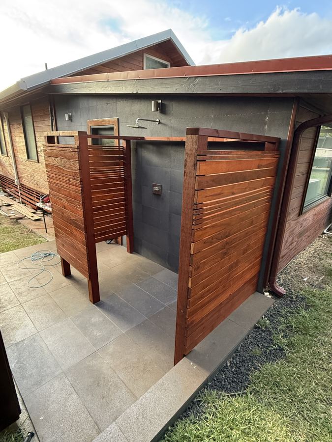 Two slat-wood enclosures on a stone patio